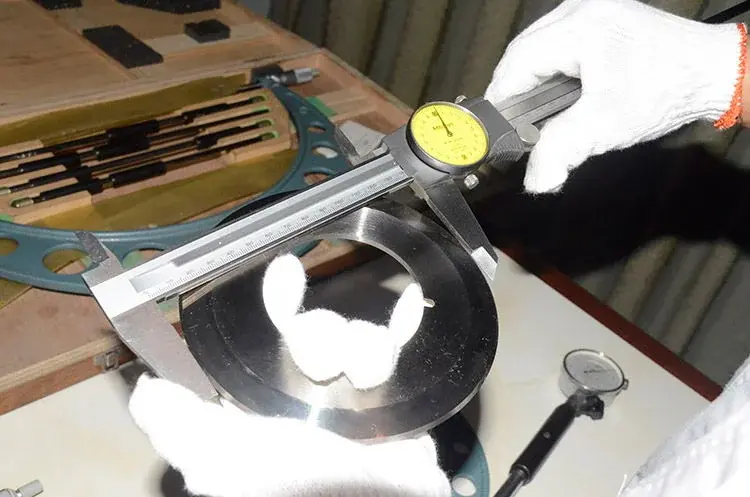 Dial caliper held across the outside diameter of a circular knife