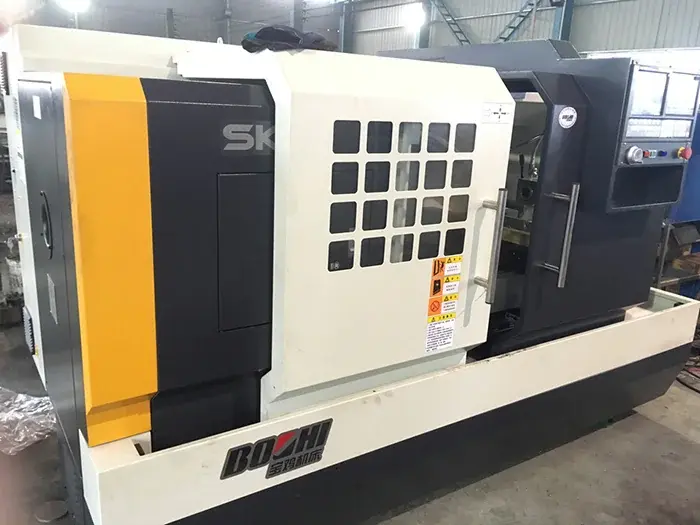 Enclosed CNC lathe with its control panel visible