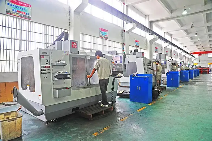 Operators alongside machining equipment in a workshop